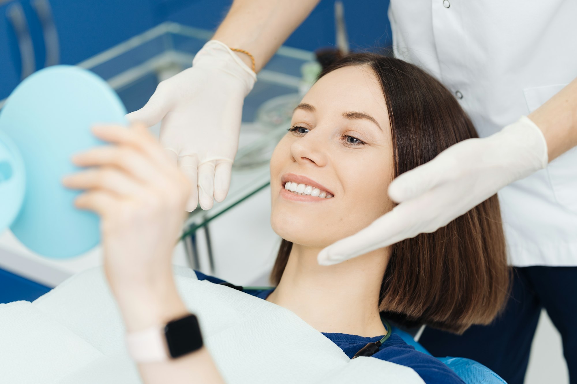 Dentist hands and happy patient looking in mirror after treatment